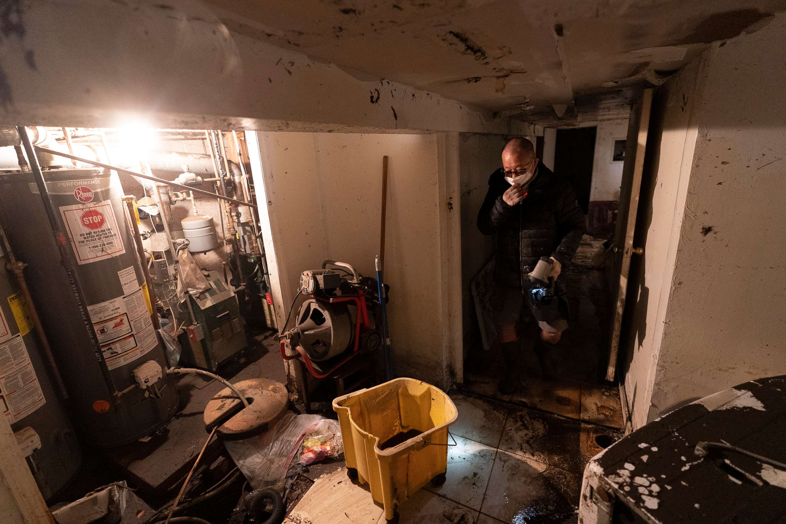 PHOTO: A man who gave his name as John, helps clean a friend's basement, Sept. 3, 2021 in Queens, N.Y.