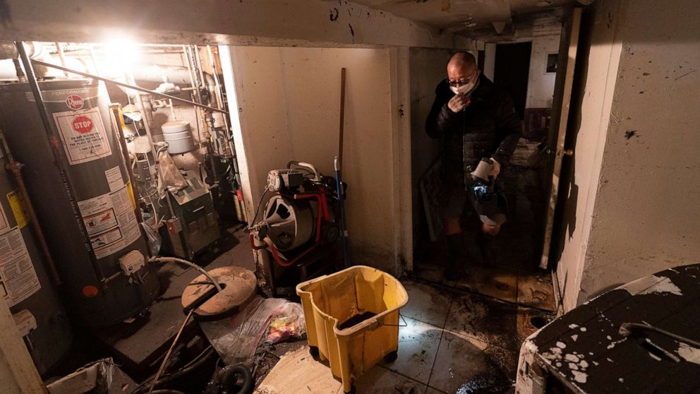 PHOTO: A man who gave his name as John, helps clean a friend's basement, Sept. 3, 2021 in Queens, N.Y.