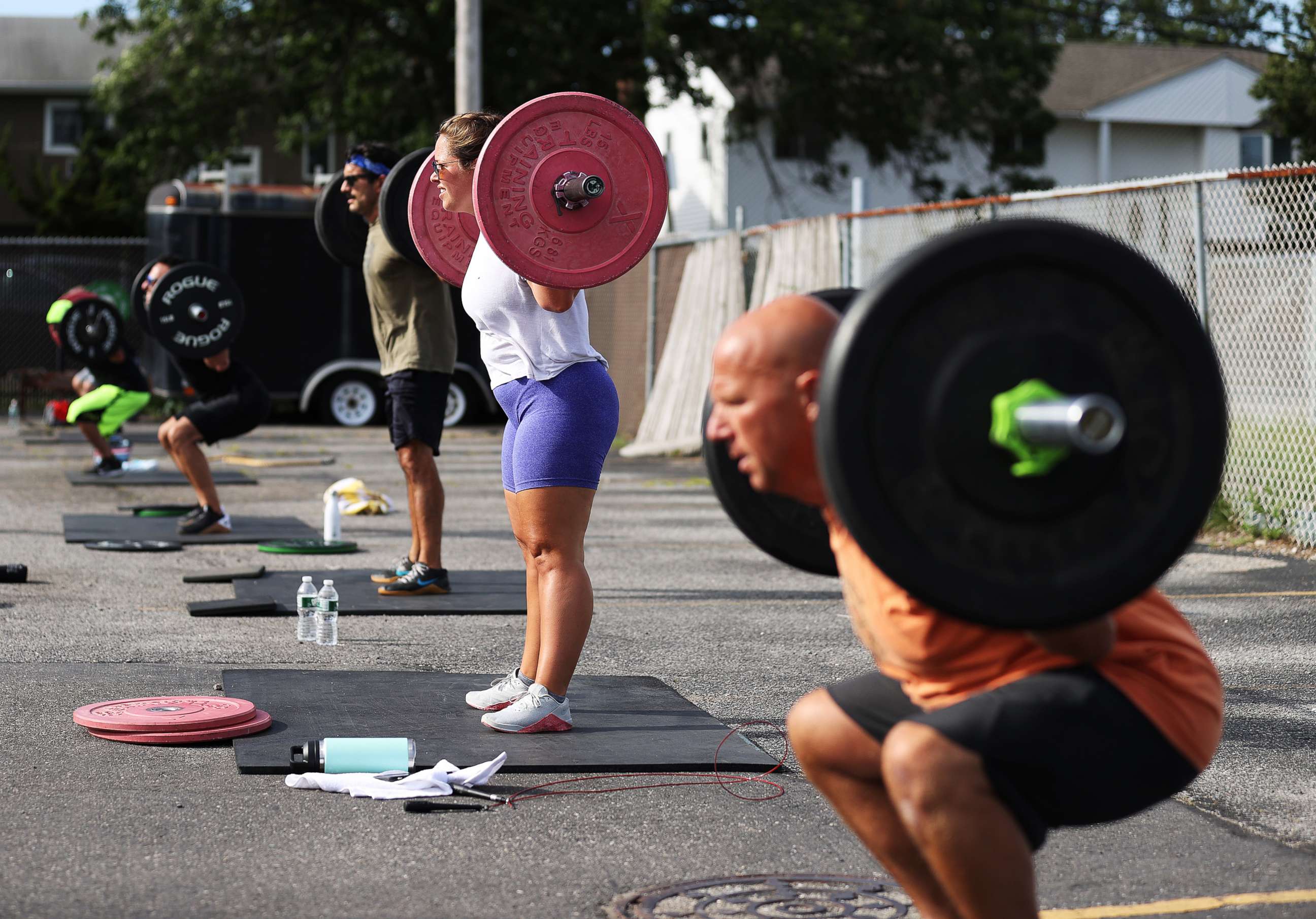 PHOTO: Taylor Wroblewski and her Dad Frank squat during an outdoor Jetty Gym "Outside The Box" fitness workout, July 20, 2020, in Oceanside, New York.