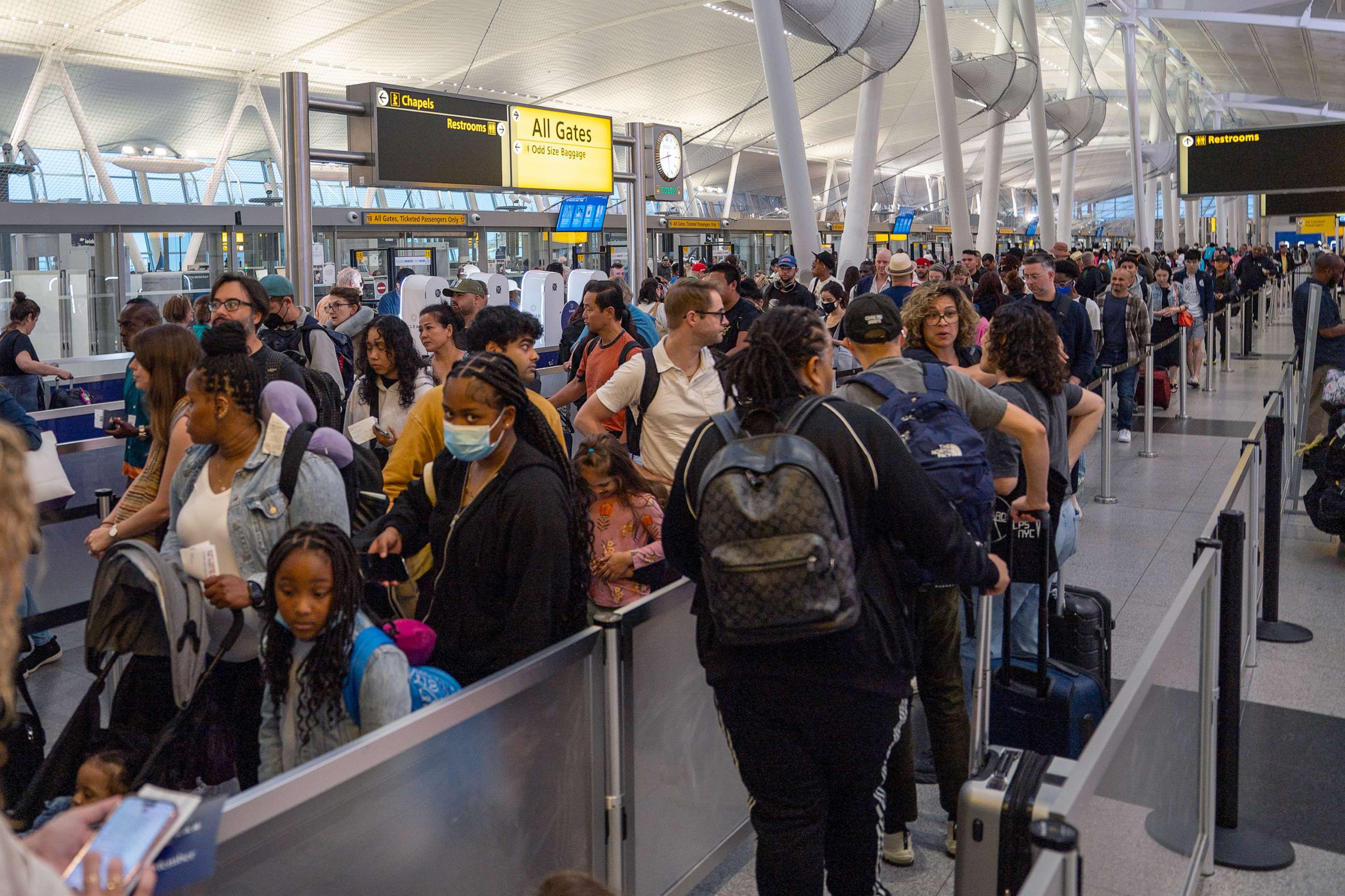 PHOTO: People wait in line at the security checkin of JFK International airport on June 30, 2023, in New York City, as travel begins for the Fourth of July holiday.