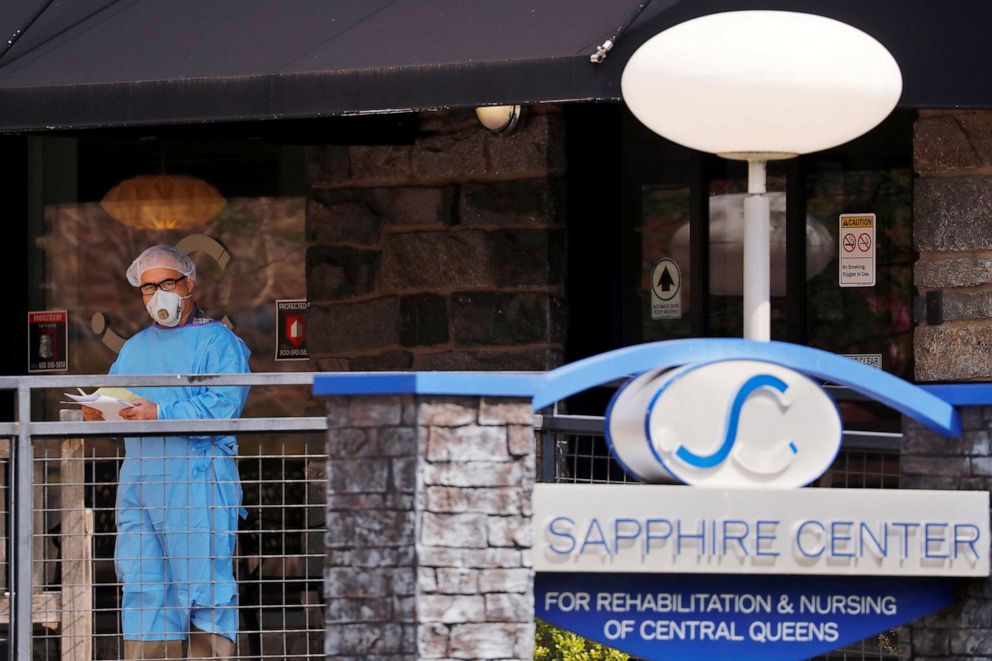 PHOTO: A man wearing PPE stands behind a sign for the Sapphire Center nursing home after reports of a number of deaths there came to light during an ongoing outbreak of coronavirus  (COVID-19) in the Brooklyn borough of New York, April 17, 2020.