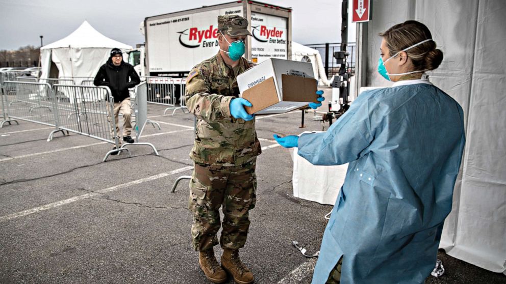 PHOTO: A National Guard soldier handles COVID-19 swab tests at a drive-thru testing center at Lehman College, on March 28, 2020, in the Bronx, New York City. The center, opened March 23, can test up to 500 people per day for the coronavirus. 