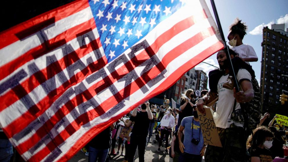 PHOTO: A child sits on her father's shoulders as he carries a U.S. flag during a protest against racial inequality in the aftermath of the death in Minneapolis police custody of George Floyd, in the Brooklyn borough of New York City, June 7, 2020.