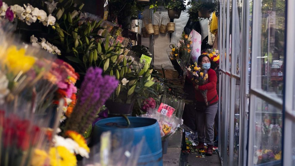 PHOTO: A woman holds flowers inside a bodega on May 10, 2020 in New York City. 