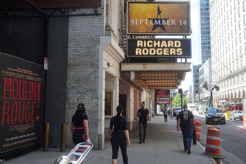PHOTO: People walk past Broadway show marquees during the coronavirus pandemic in the Manhattan borough of New York City, May 13, 2021.