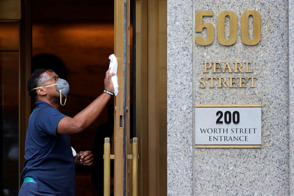 PHOTO: A worker cleans the entrance to the Manhattan Federal Court, during the arraignment hearing of Ghislaine Maxwell for her role in the sexual exploitation and abuse of minor girls by Jeffrey Epstein, in New York City, on July 14, 2020.
