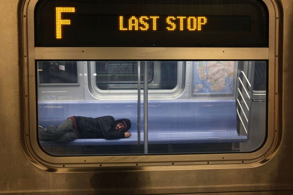 PHOTO: A person sleeps on a New York City subway car, May 7, 2020 in New York City.