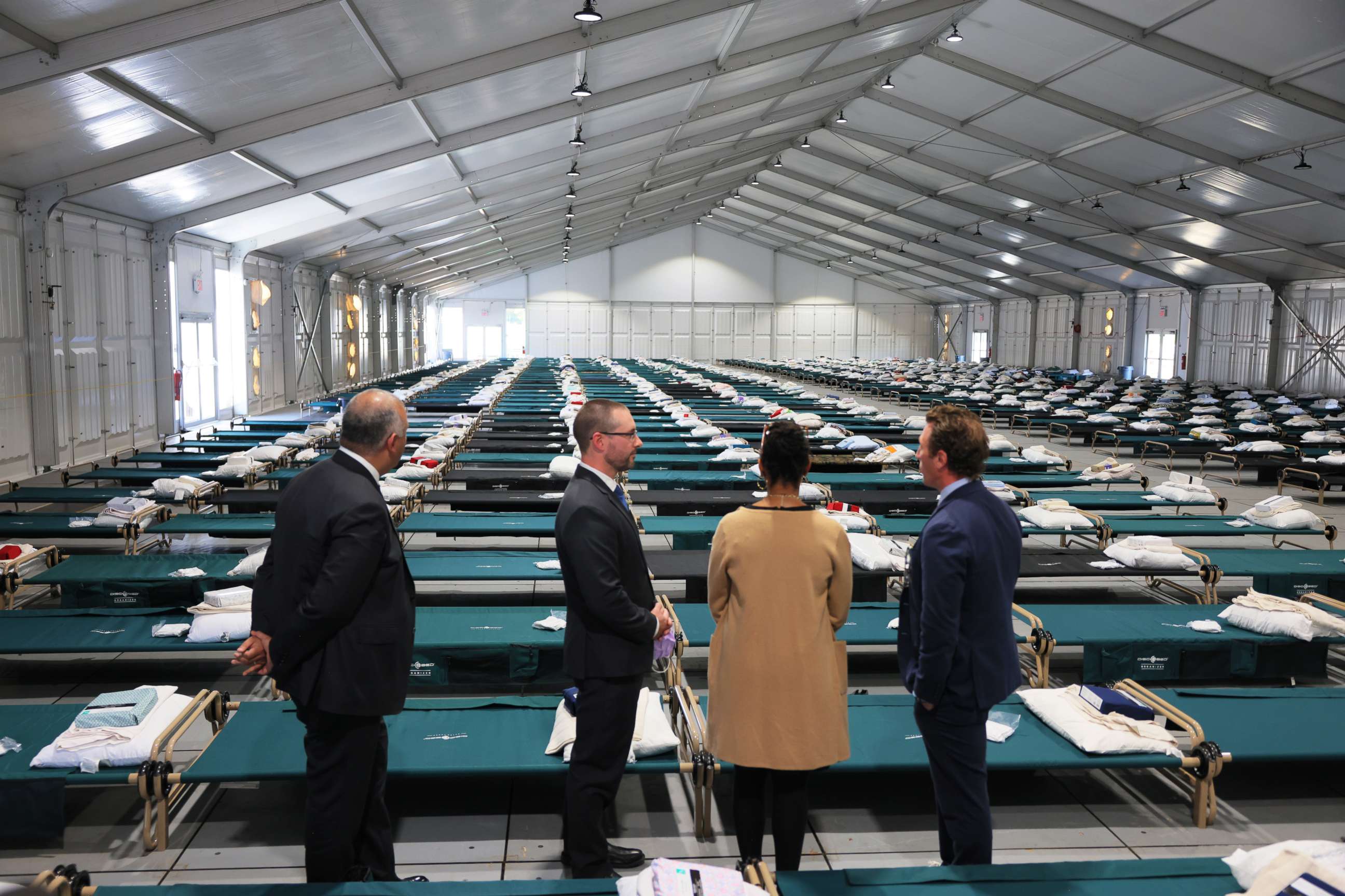 PHOTO:Officials look out into the dormitory during a tour of the Randall's Island Humanitarian Emergency Response and Relief Center on Oct. 18, 2022, in New York City.