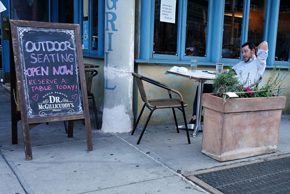 PHOTO: A restaurant serves customers seated at outside tables as the city moves into phase 2 of reopening following restrictions imposed to curb the coronavirus pandemic on June 22, 2020 in New York City.