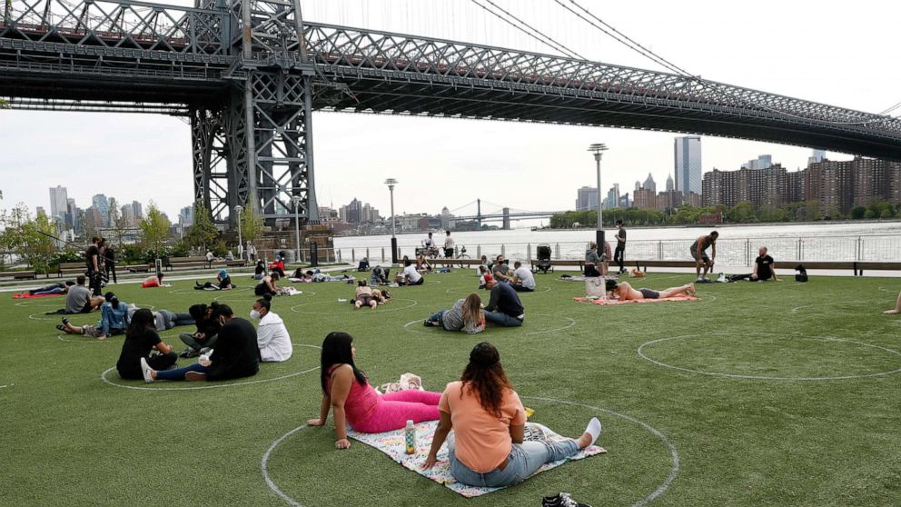PHOTO: People relax in circles marked on the grass for proper social distancing at Brooklyn's Domino Park during the coronavirus outbreak, May 18, 2020, in New York.