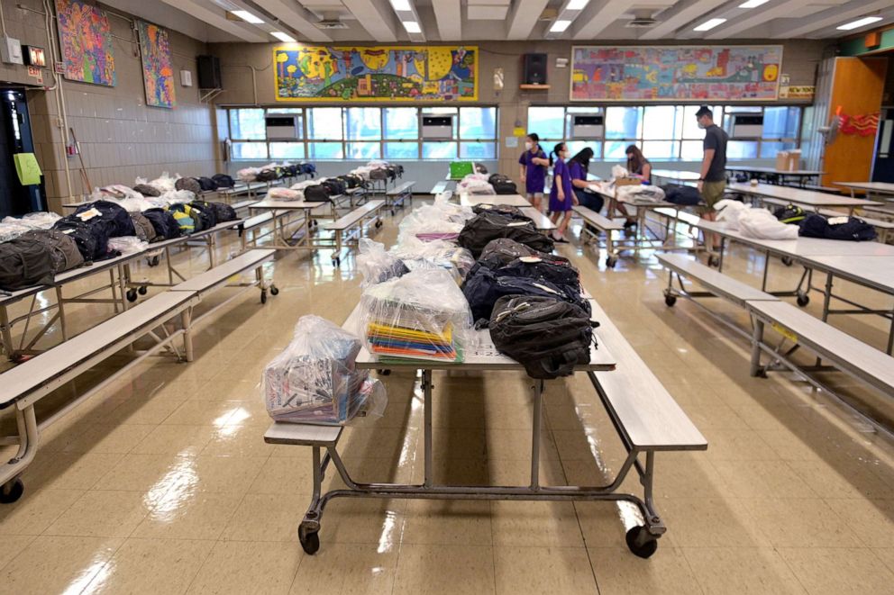 PHOTO: Rows of cafeteria tables are reserved for gifts and personal items left behind before schools were shut down to be picked up by students who just graduated at Yung Wing School P.S. 124 on June 29, 2020 in New York City. 