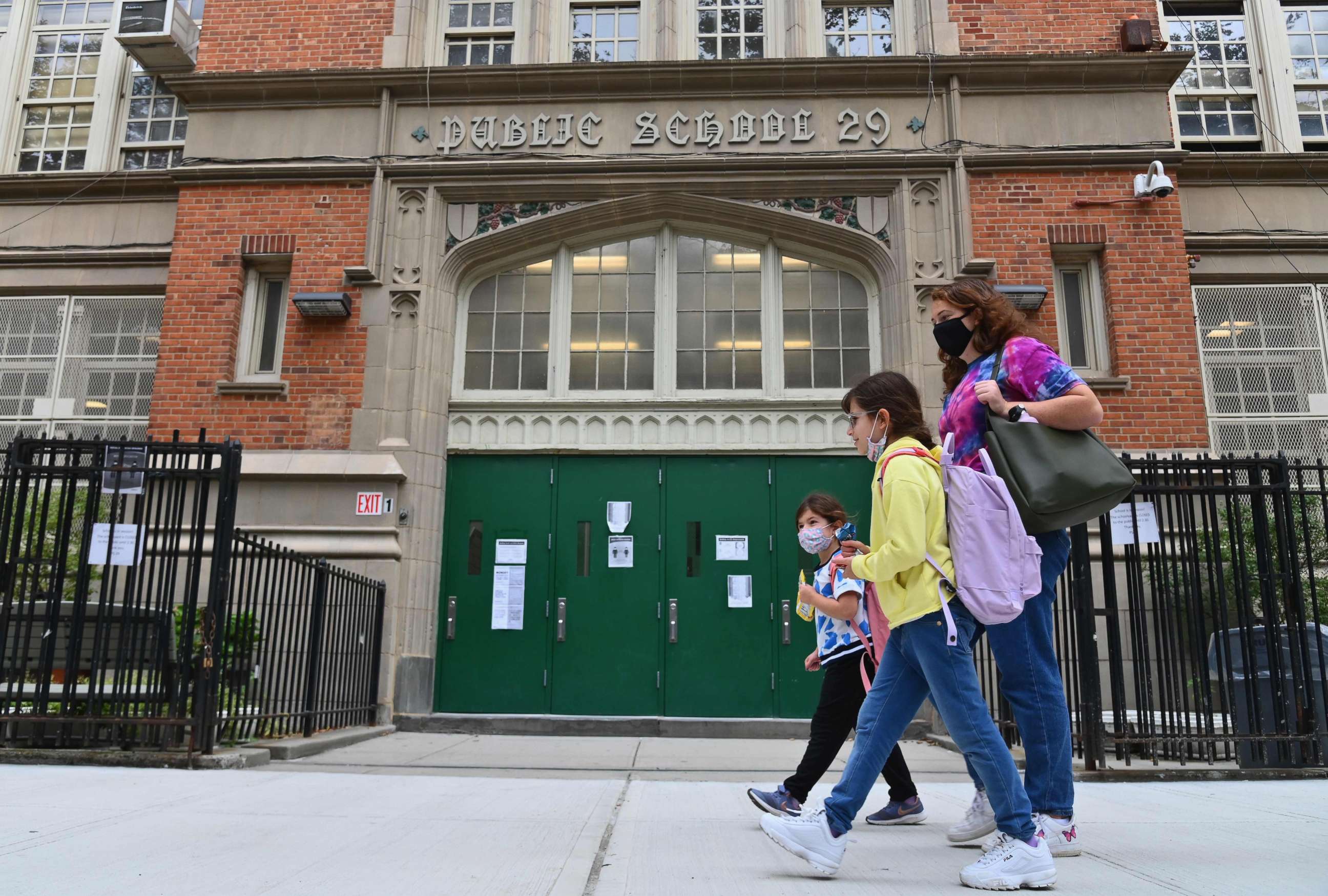 PHOTO: (FILES) In this file photo students walk past a public school on October 5, 2020 in the Brooklyn Borough of New York City. 