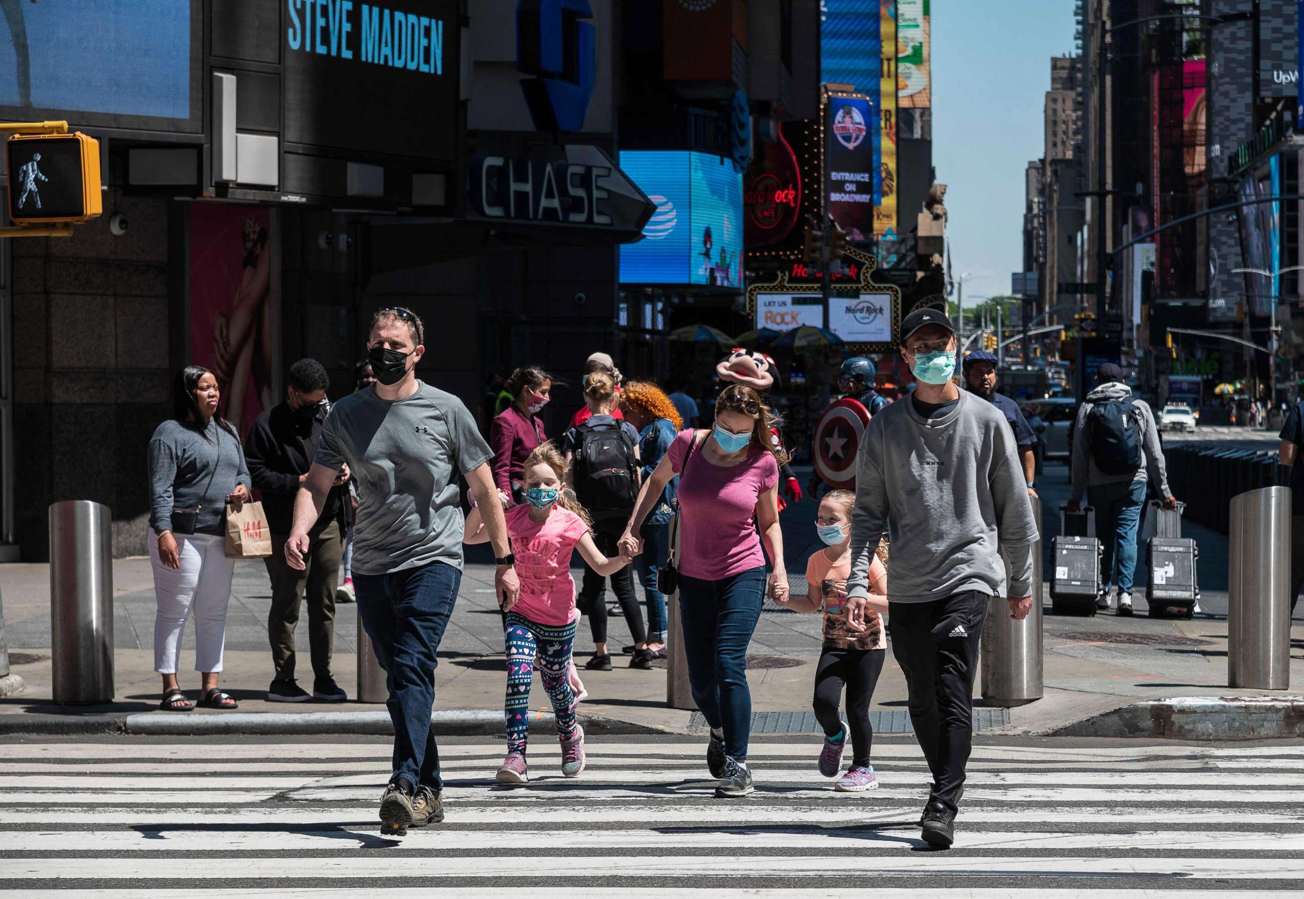 PHOTO: People wearing face masks walk through Times Square, May 17, 2021, in New York City.