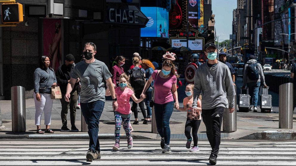 PHOTO: People wearing face masks walk through Times Square, May 17, 2021, in New York City.