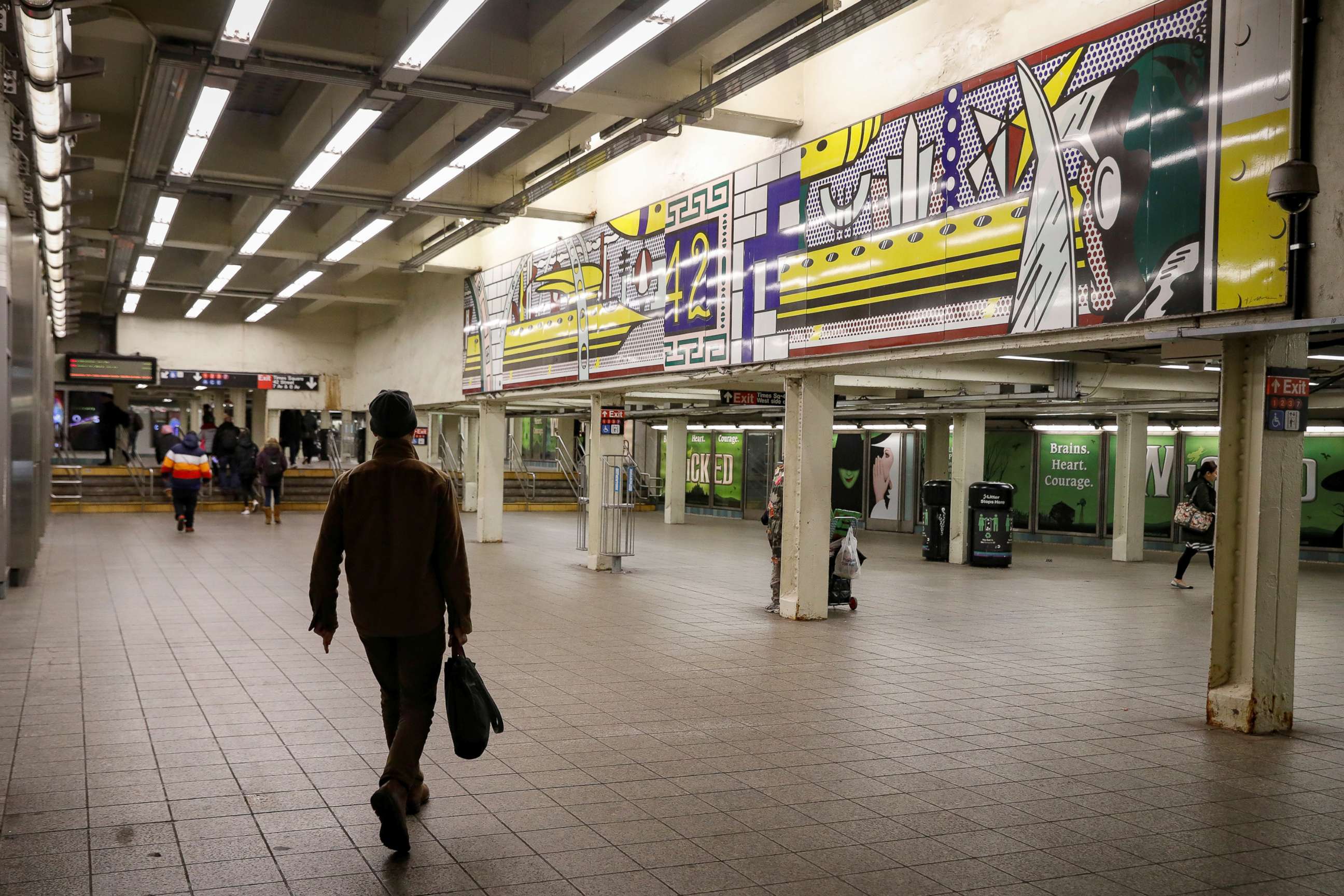 PHOTO: A man walks through a nearly empty Times Square - 42nd St. subway station during the morning rush in New York City, March 16, 2020.