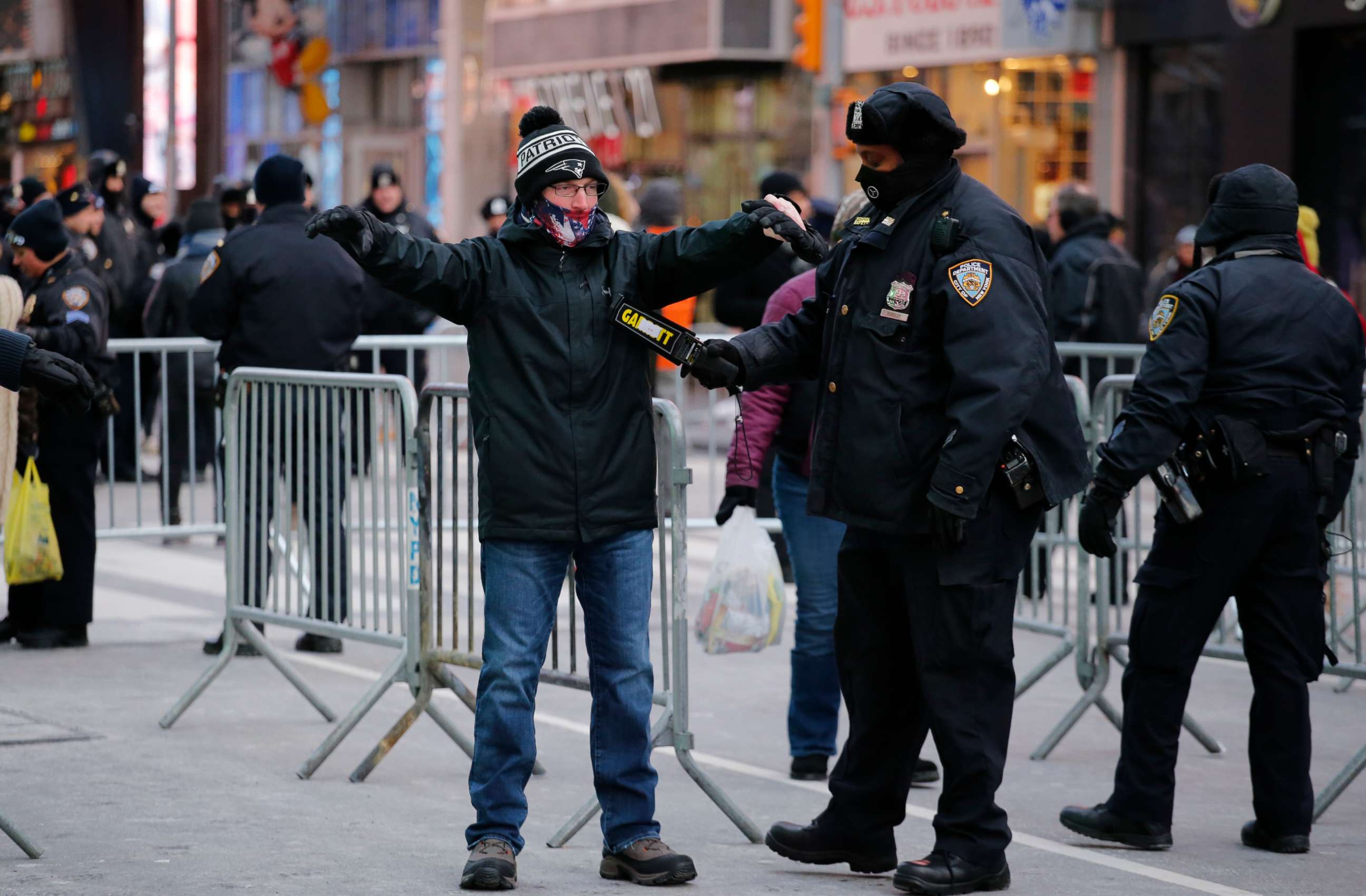 PHOTO: A New York Police Department officer checks a reveler in Times Square prior to New Year's Eve celebrations on Dec. 31, 2017, in New York.