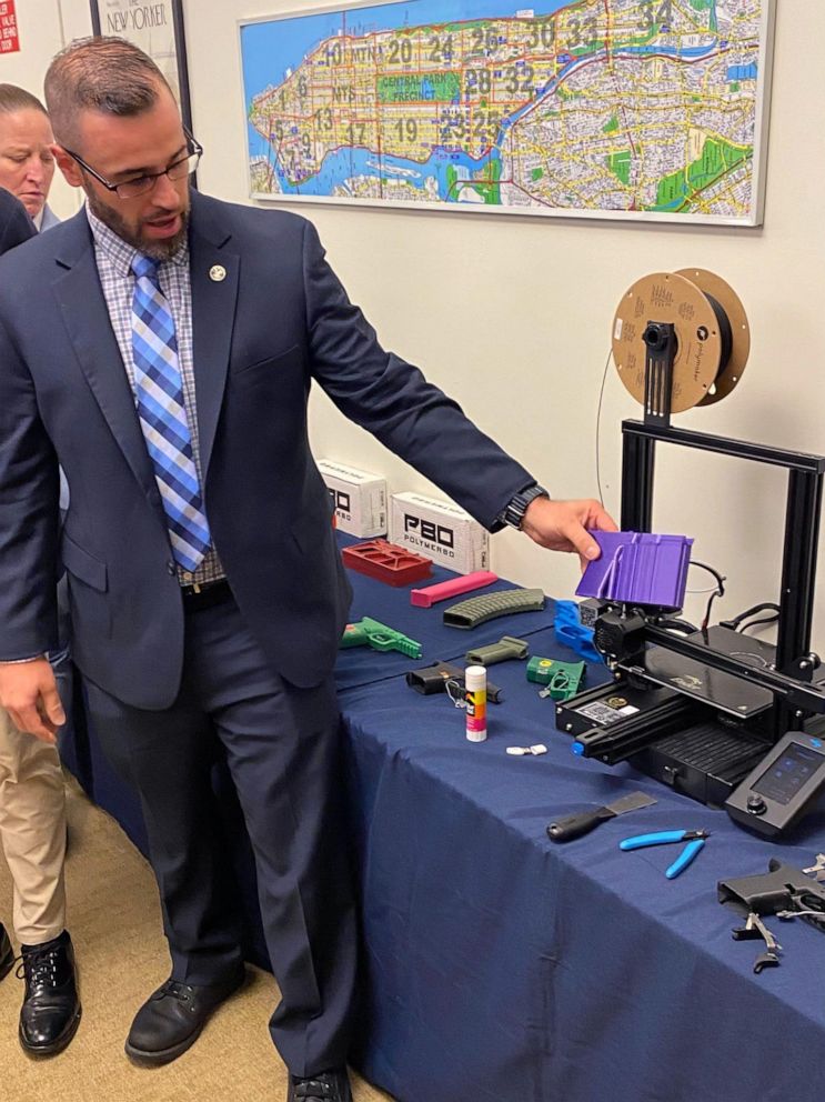 PHOTO: An NYPD detective demonstrates how a 3D printer is able to print gun components.