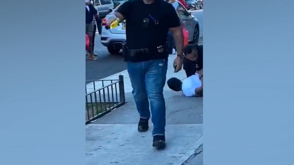 PHOTO: In this screen grab taken from a video, an NYPD officer is shown aiming a taser at a person watching an arrest being made.