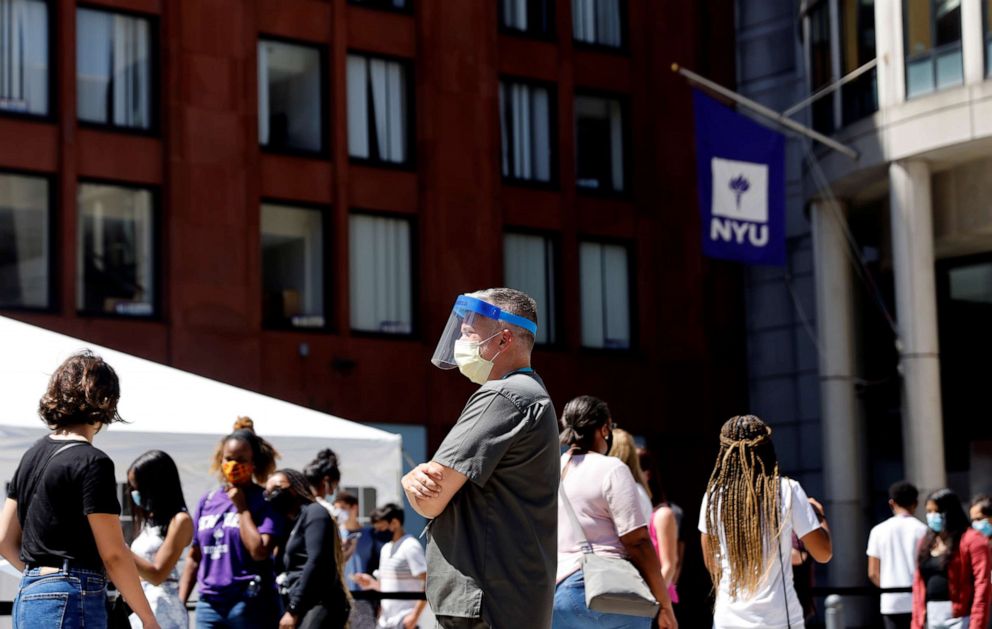 PHOTO: A health care worker looks on as people wait in line at a testing site for COVID-19 set up for returning students, faculty and staff on the main New York University campus in New York City on Aug. 18, 2020.