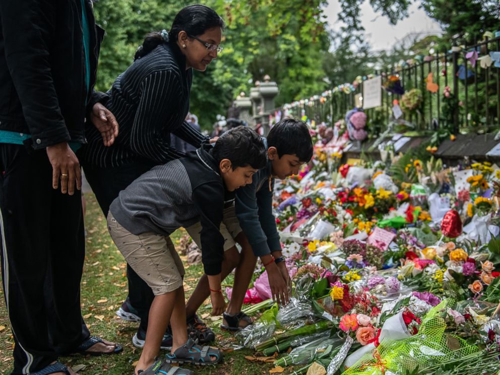 PHOTO: A family lay flowers by the wall of the Botanic Gardens, March 17, 2019 , in Christchurch, New Zealand after a mass shooting at two mosques.