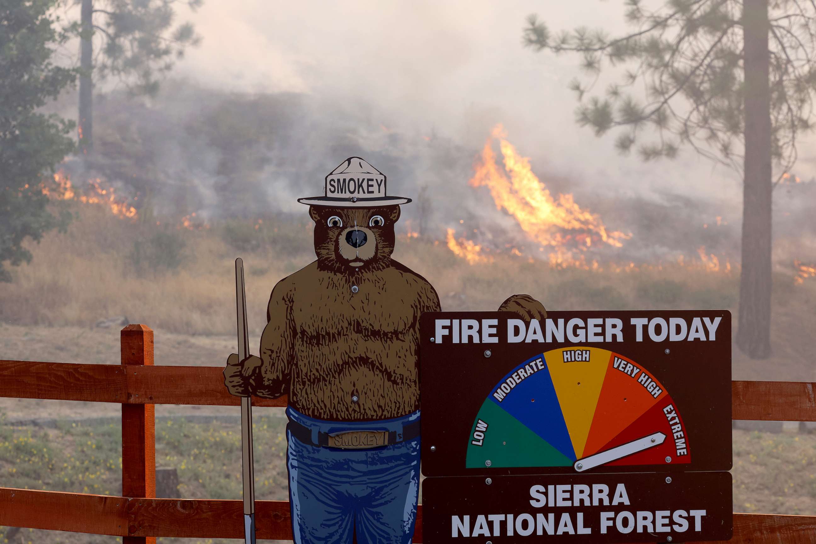 PHOTO: Fire burns near a Smokey the Bear fire warning sign as the Oak Fire burns through the area near Jerseydale, Calif., July 24, 2022.