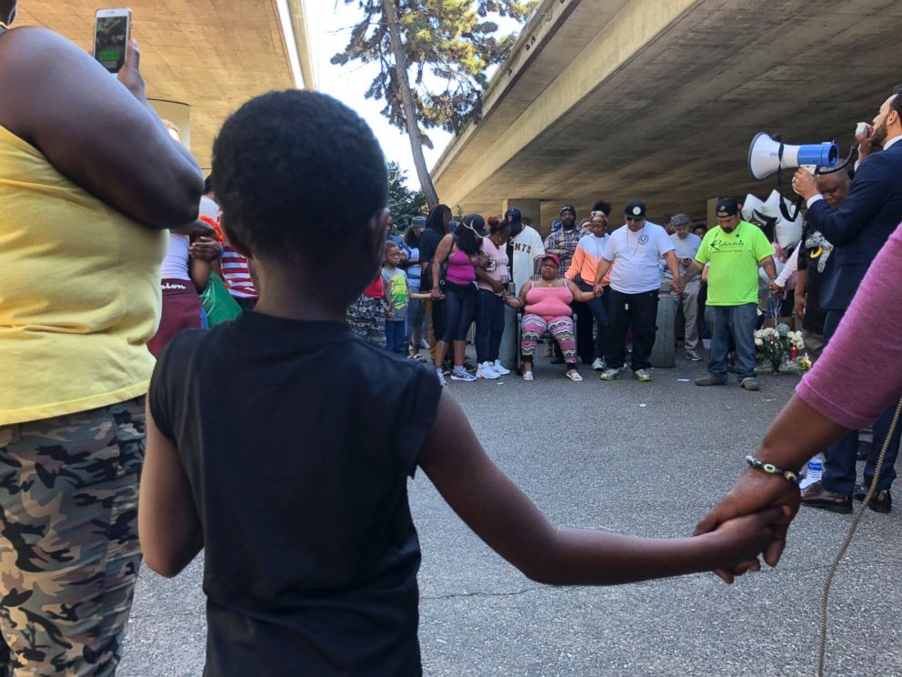 People hold hands during a vigil for Nia Wilson outside the MacArthur Bay Area Rapid Transit station, in Oakland, Calif., July 23, 2018.