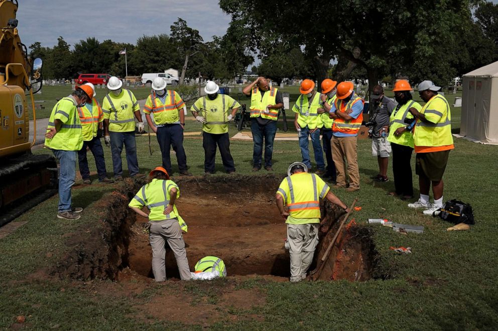 PHOTO: Archaeologists and researchers examine a hole that was dug during a test excavation of the possible 1921 Tulsa Race Massacre Graves at Oaklawn Cemetery in Tulsa, Oklahoma on July 13, 2020.
