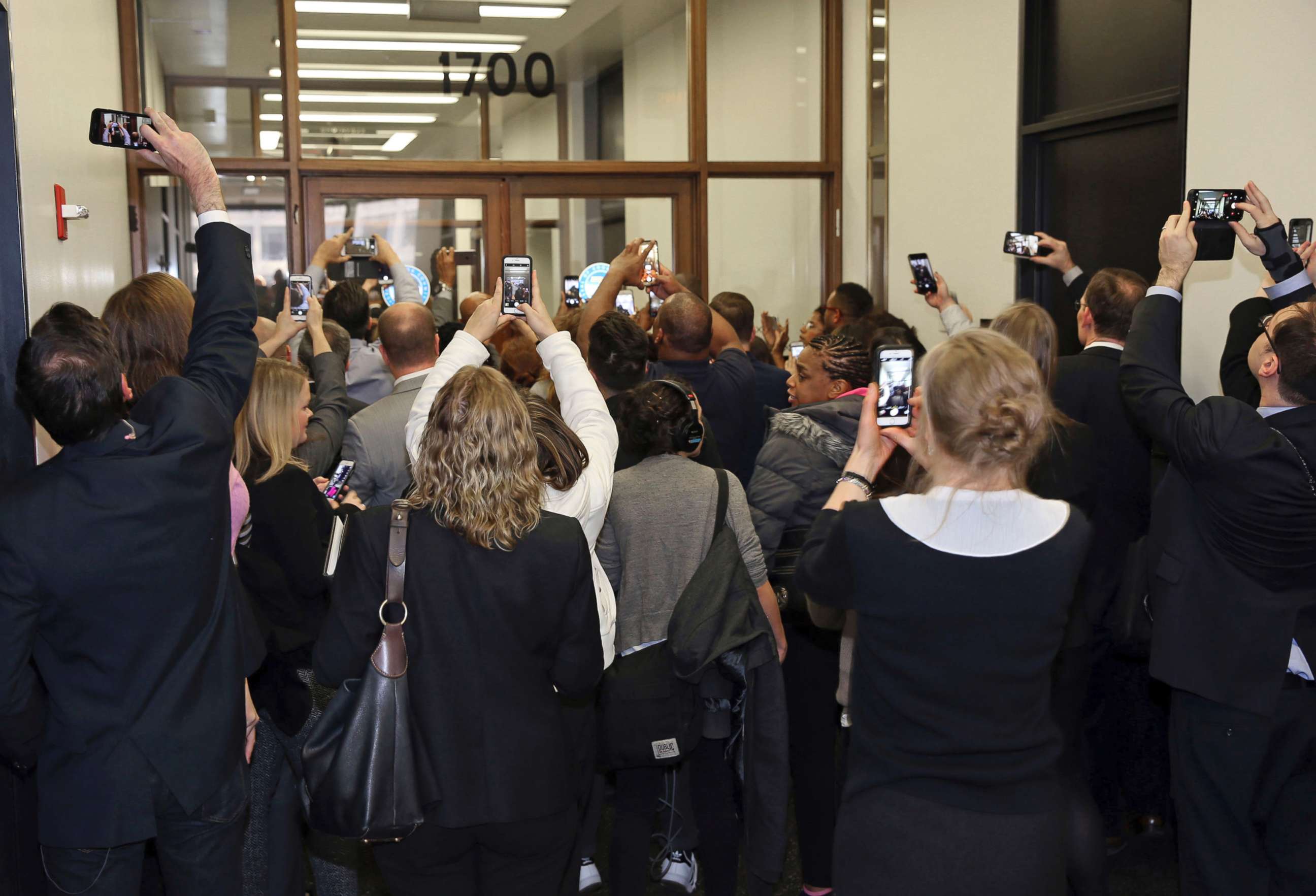 PHOTO: People rush the doors of the jury assembly room as former President Barack Obama arrives for jury duty in the Daley Center on Nov. 8, 2017, in Chicago, Ill.  Obama is to be paid the same $17.20 a day that others receive for reporting for jury duty.