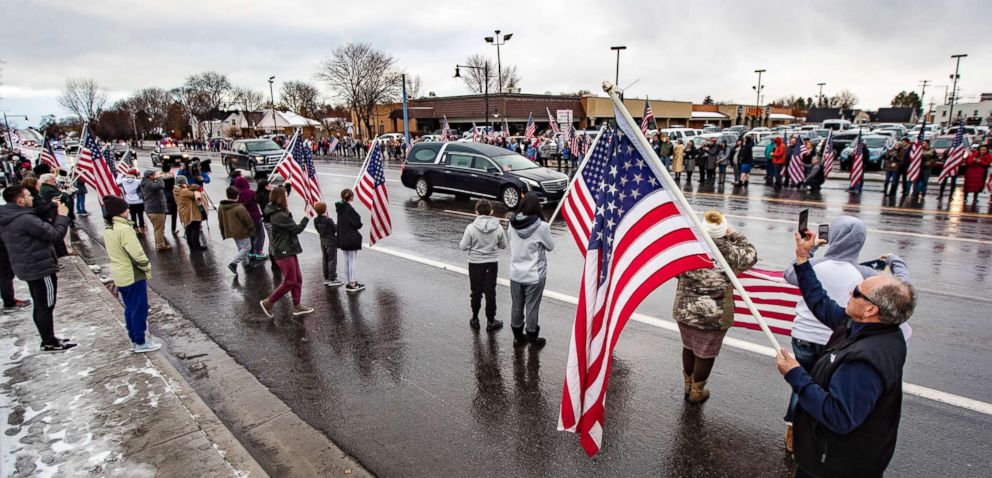 PHOTO: Residents hold American flags in honor of Provo Police Officer Joseph Shinners' body during a procession in Provo, Utah, Jan. 6, 2019.