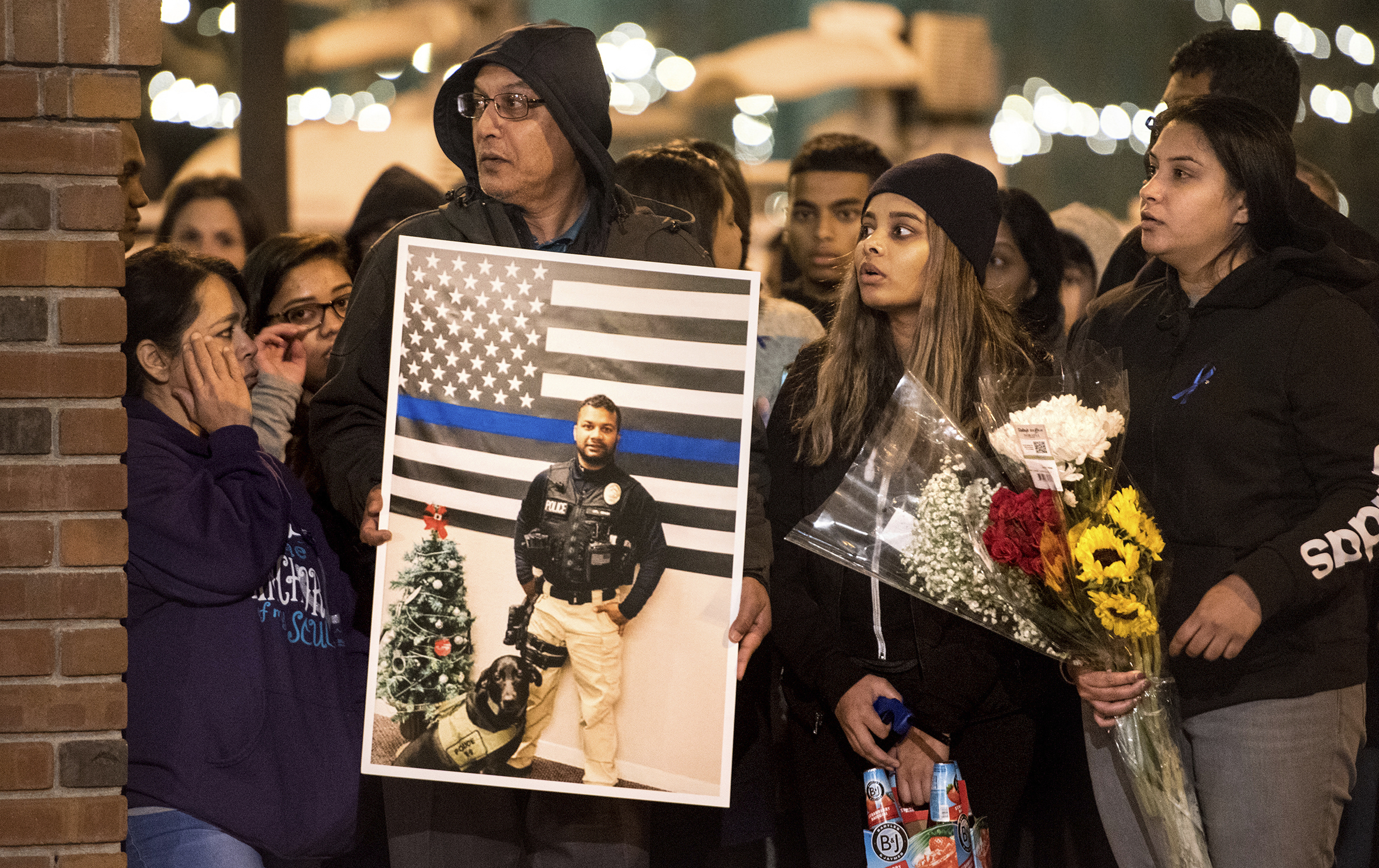 PHOTO: Family members of police Cpl. Ronil Singh including Birend Singh, holding picture at left, attend a candlelight vigil for the slain officer in downtown Newman, Calif., Dec. 28, 2018. 