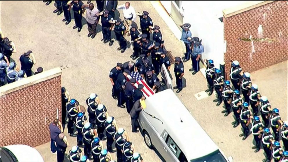 PHOTO: An image made from aerial video shows police officers saluting the casket containing the remains of Police Officer Michael Chesna as it departs the Boston Medical Examiner's office to be taken to a funeral home in Boston, July 16, 2018.