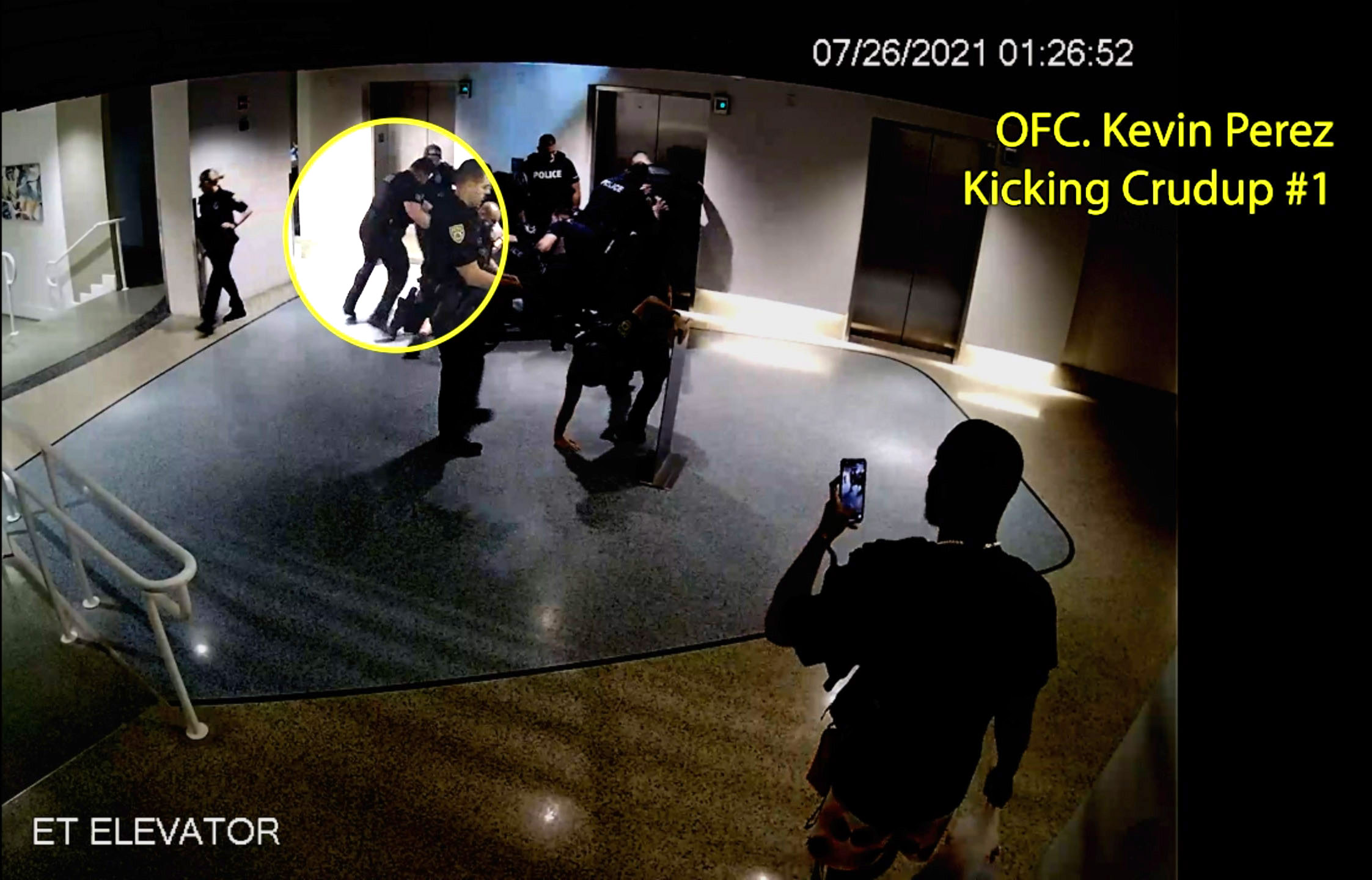 PHOTO: Officer Kevin Perez is seen as he motions to kick Dalonta Crudup while Khalid Vaughn stands on the far right recording video with his phone, in an image taken from hotel surveillance video released by the Miami-Dade State Attorney’s Office.