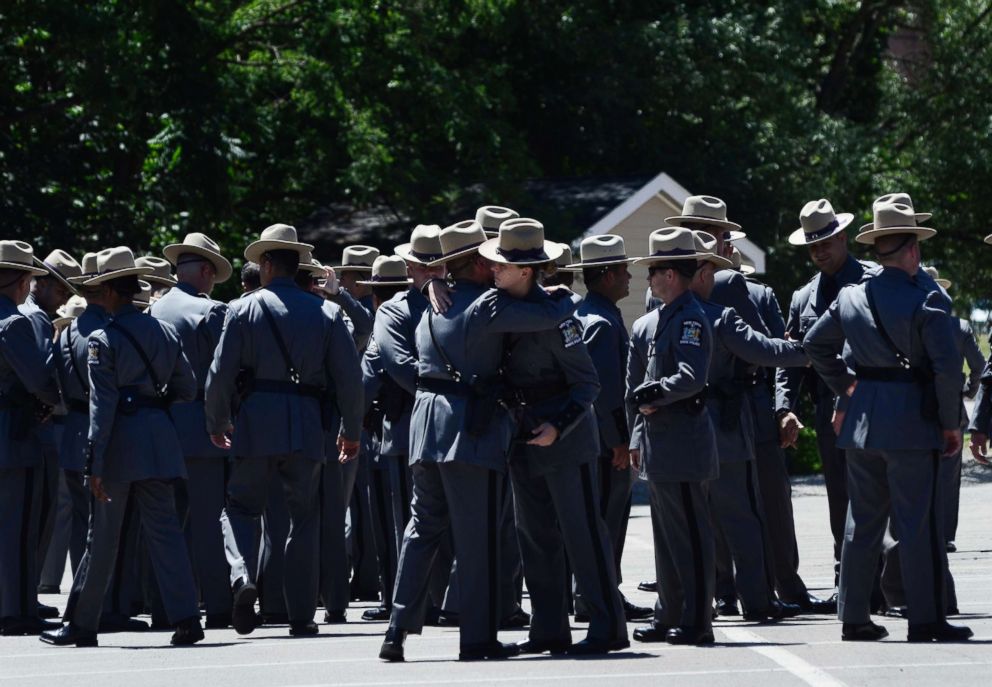 PHOTO: New York State Police Troopers embrace before leaving the funeral service for fellow Trooper Nicholas F. Clark, July 8, 2018, at Alfred University in Alfred, N.Y. 