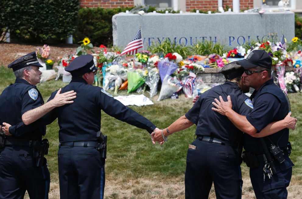 PHOTO: Weymouth Police officers embrace after the procession for slain Weymouth Police officer Michael Chesna, 42, passed by the Weymouth Police station in Weymouth, Mass., July 16, 2018.