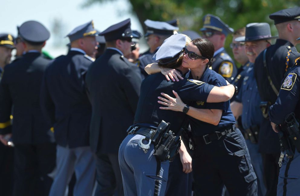 PHOTO: Police officers console one another while waiting to get into the viewing for slain Baltimore County police officer Amy Caprio in Nottingham, Md., May 24, 2018.