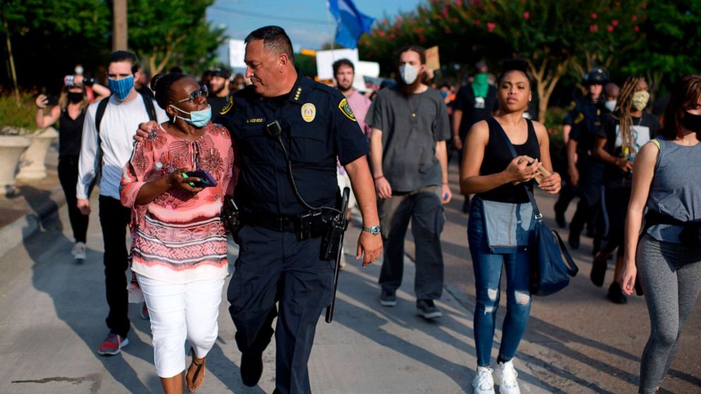PHOTO: Houston Police Chief Art Acevedo walks arm-in-arm with a woman during a "Justice for George Floyd" event in Houston, Texas, May 30, 2020, after George Floyd died while being arrested and pinned to the ground by a Minneapolis police officer.