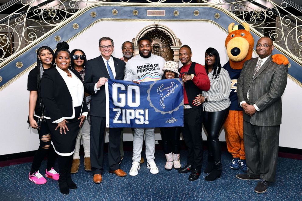 PHOTO: Michael Sutton and Kenny Phillips pose at the University of Akron with their families.