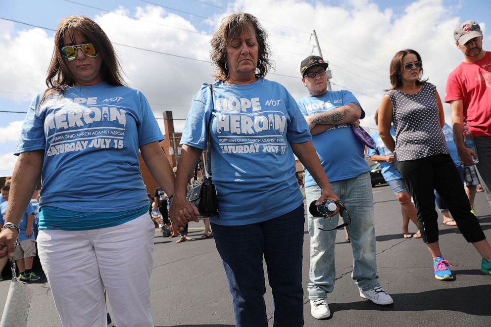 PHOTO: People pray before setting out on a march through the streets against the epidemic of heroin in their community on July 14, 2017, in Norwalk, Ohio.