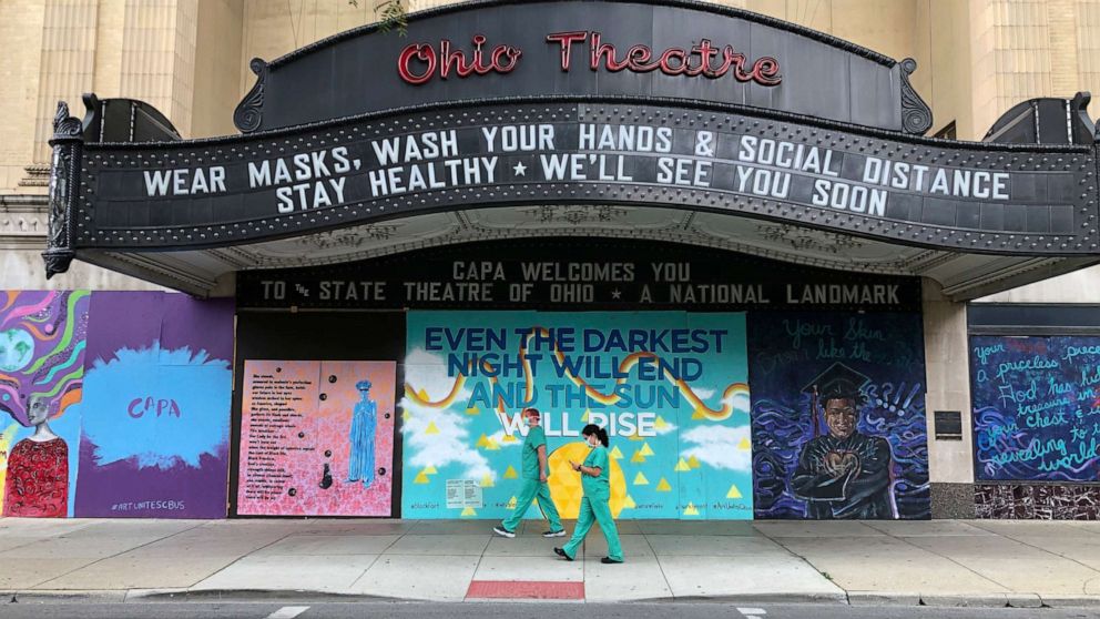 PHOTO: Workers in scrubs and masks walk past the Ohio Theatre in Columbus, Ohio, Aug. 26, 2020, amid the coronavirus pandemic.