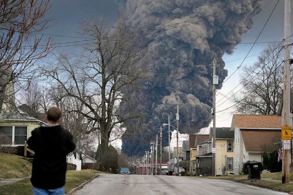 PHOTO: FILE - A man takes photos as a black plume rises over East Palestine, Ohio, as a result of a controlled detonation of a portion of the derailed Norfolk Southern train, Feb. 6, 2023.
