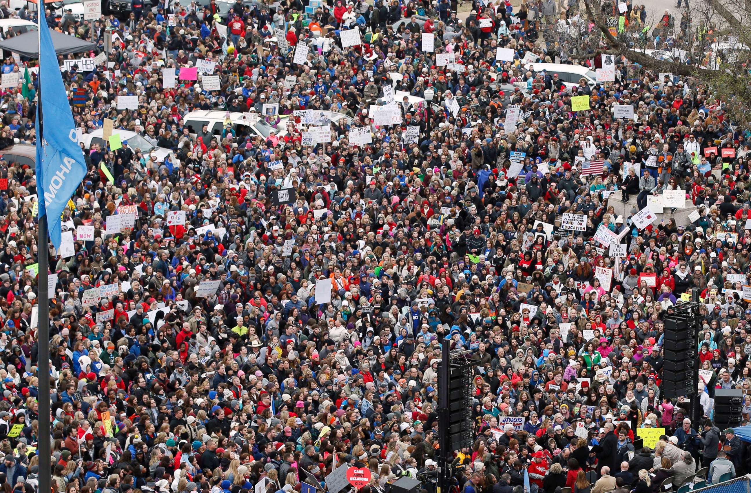 PHOTO: A crowd listens to speakers on a stage, lower right, during a teacher rally to protest low student funding at the state Capitol in Oklahoma City, April 2, 2018.