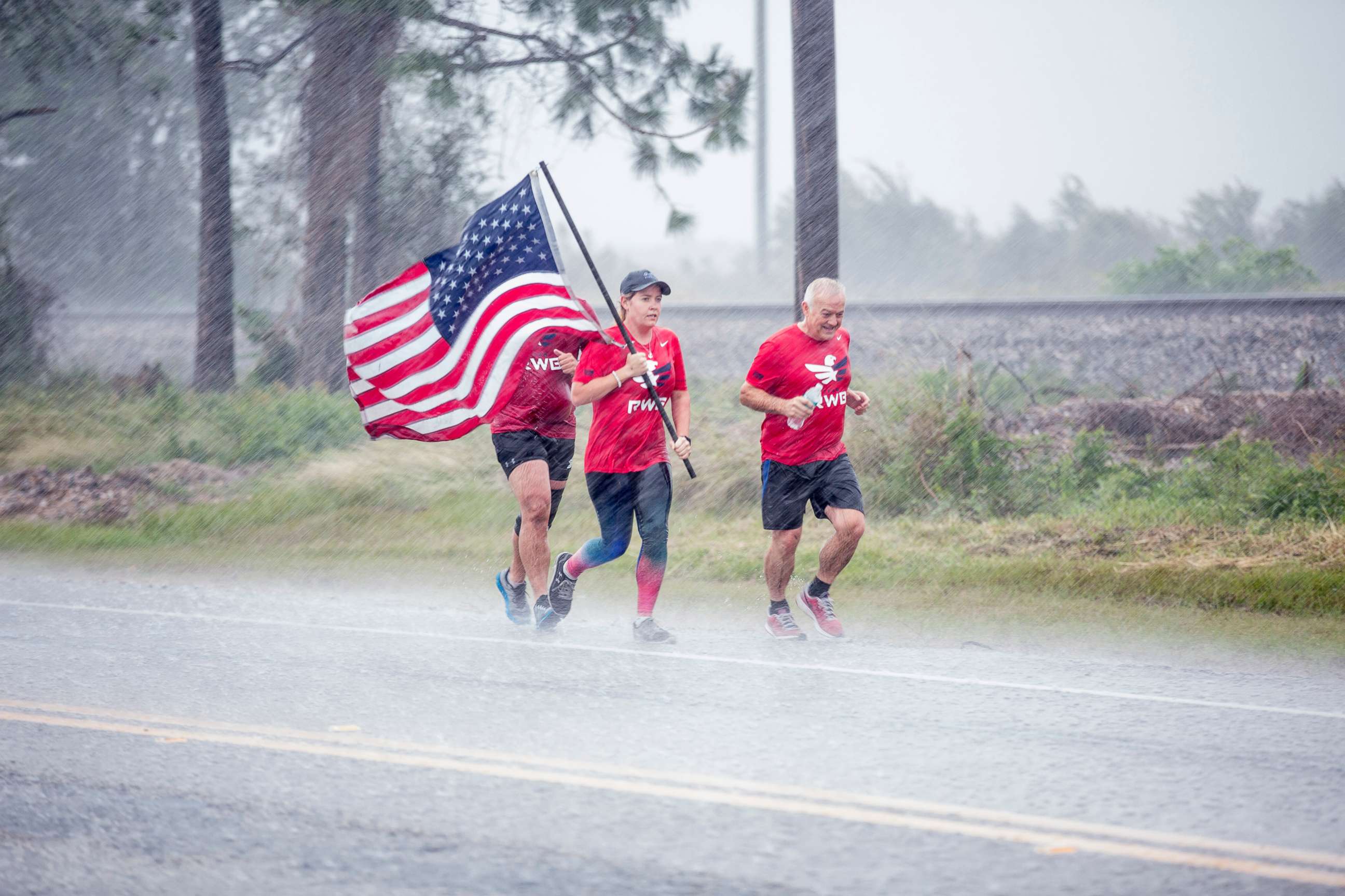 PHOTO: Runners enduring the rain and carrying the American flag in Brookshire, Texas, Oct. 22, 2017. 