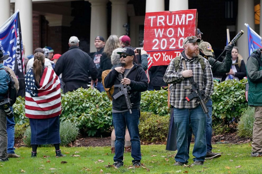 PHOTO: Supporters of President Trump, including those with guns and a bat, stand outside the Governor's Mansion after breaching a perimeter fence, Jan. 6, 2021.