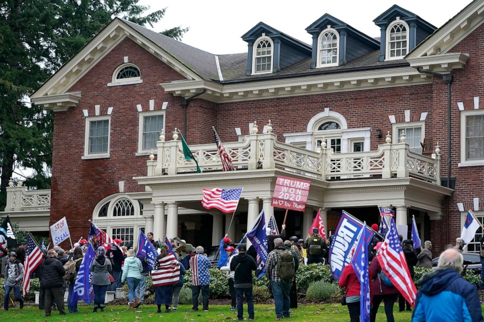 PHOTO: Protesters stand outside the Governor's Mansion after getting through a perimeter fence, Jan. 6, 2021, at the Capitol in Olympia, Wash.