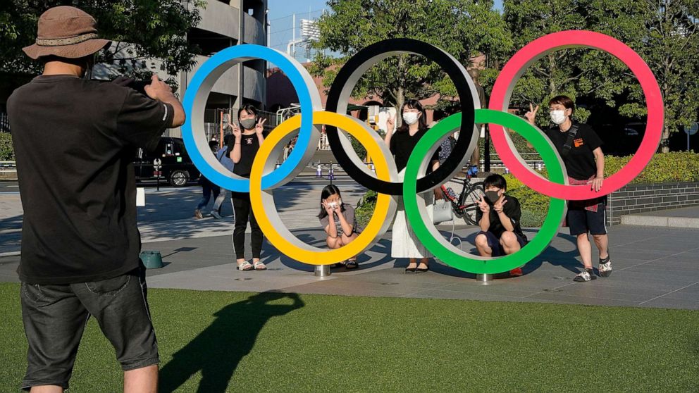 PHOTO: Visitors take commemorating photos with an Olympic Rings monument at the Japan Olympic Committee (JOC) near the New National Stadium, an Olympic Stadium for the Tokyo 2020, in Tokyo, Japan, May 23, 2021.