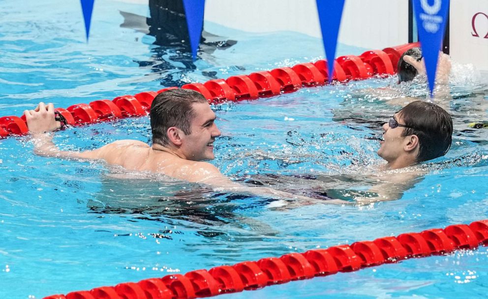 PHOTO: Evgeny Rylov (R) and Kliment Kolesnikov (L) of ROC celebrate after winning the gold and silver medals in the final of the men's 100m backstroke swimming during the 2020 Olympic Games in Tokyo, July 27, 2021.