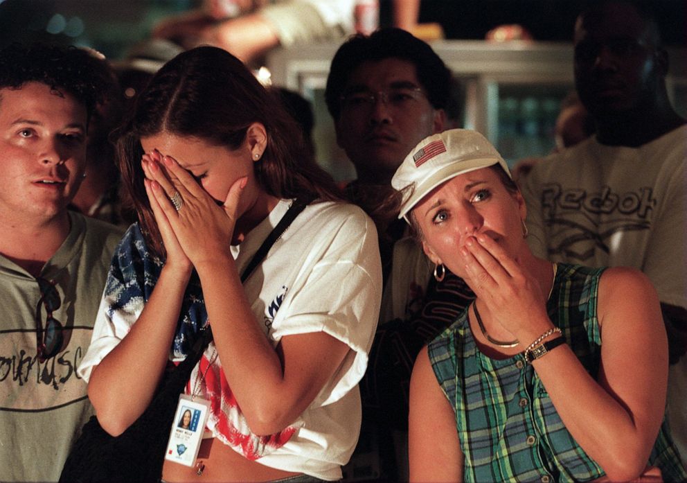 PHOTO: People who were in Atlanta's Centennial Olympic Park when the explosion occurred react to the news while watching a TV on the street near the site, July 27, 1996.