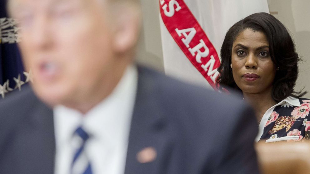 PHOTO: Omarosa Manigault (R), White House Director of Communications for the Office of Public Liaison, sits behind US President Donald Trump as he speaks during a meeting in the Roosevelt Room of the White House, Feb. 14, 2017.