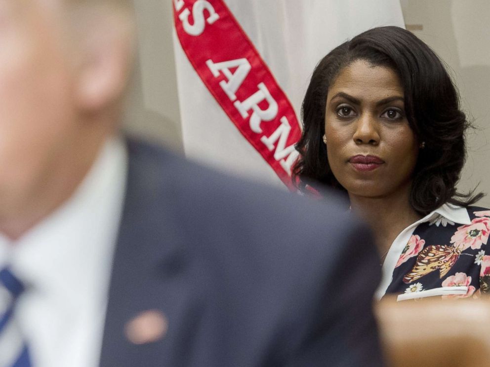 PHOTO: Omarosa Manigault (R), White House Director of Communications for the Office of Public Liaison, sits behind US President Donald Trump as he speaks during a meeting in the Roosevelt Room of the White House, Feb. 14, 2017.