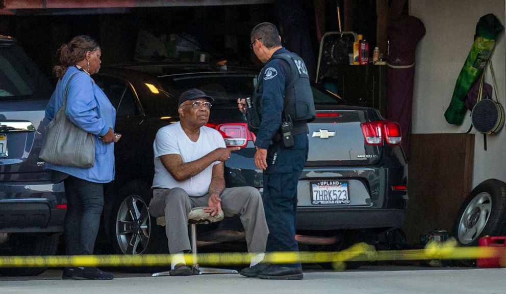 PHOTO:An Ontario Police officer interviews a neighbor sitting in his garage next door to a home where two children, an infant and a teenager, were found dead with their mother, who was unresponsive, Aug. 20, 2019, in Ontario, Calif. 